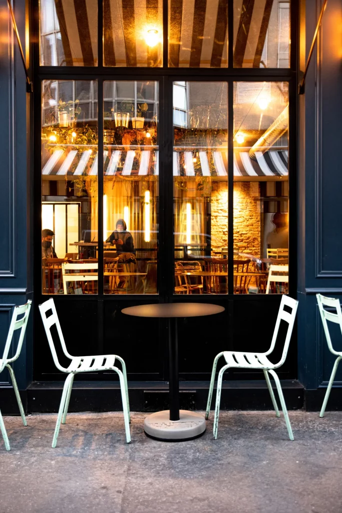 terrasse lyonnaise aménagé de tables Donut ronde et noir ainsi que de chaise en métal bleu pastel