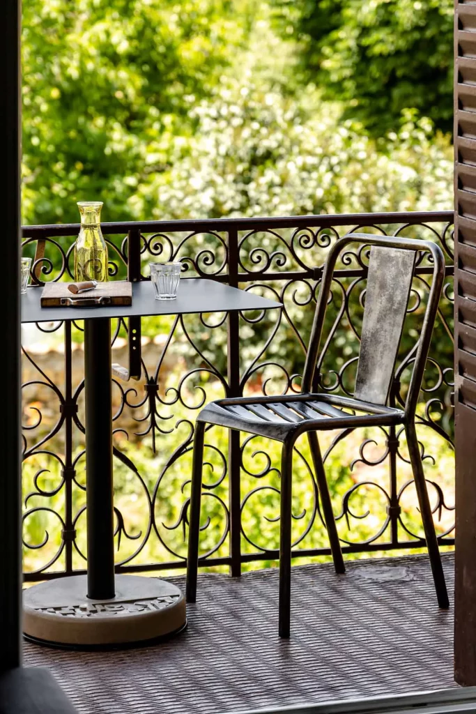 le balcon d'une maison de campagne agrémenté d'une table rectangulaire Donut en aluminium pour profiter d'un petit déjeuner au soleil