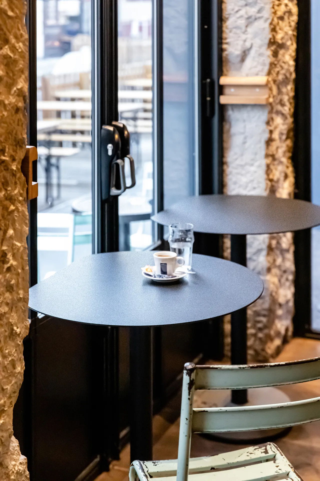 black brasserie table with cutaway top in front of the bistro terrace