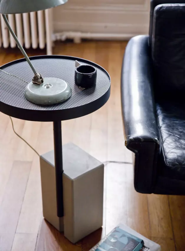 Practical side table with its swivel top, next to a vintage scandinavian leather sofa