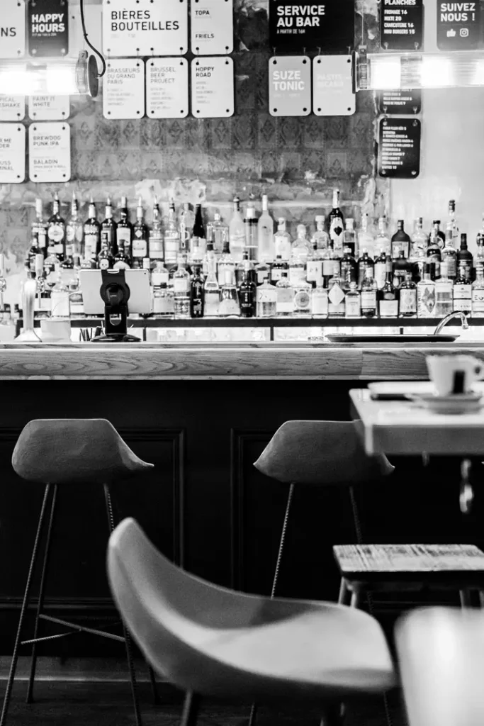 les chaises de bar Hauteville avec assise en béton moulé devant un bar en bois