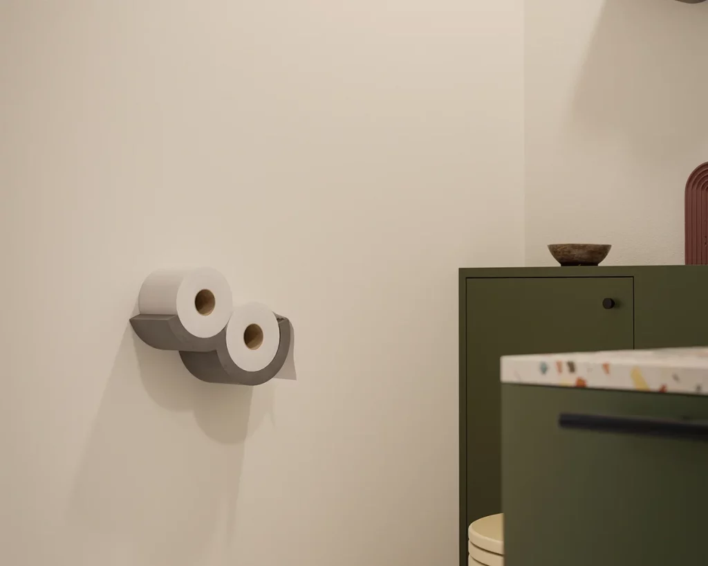 Dérouleur papier toilette Cloud en béton gris fixé au mur, avec deux rouleaux.