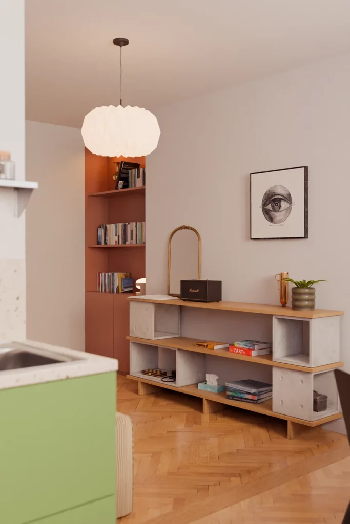 Meuble bas composé de modules Dice en béton et de planches en chêne, avec des livres et une enceinte.