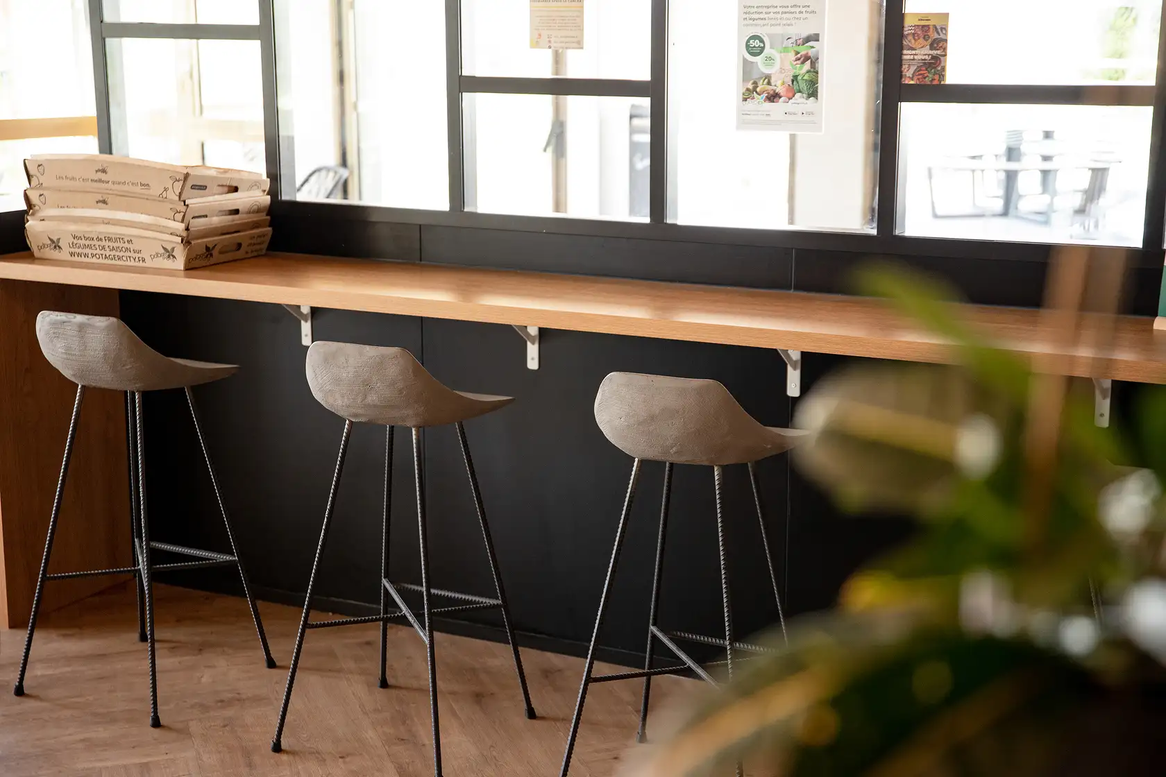 Tabourets Hauteville en béton devant comptoir en bois sur parquet chevrons — Lyon Béton