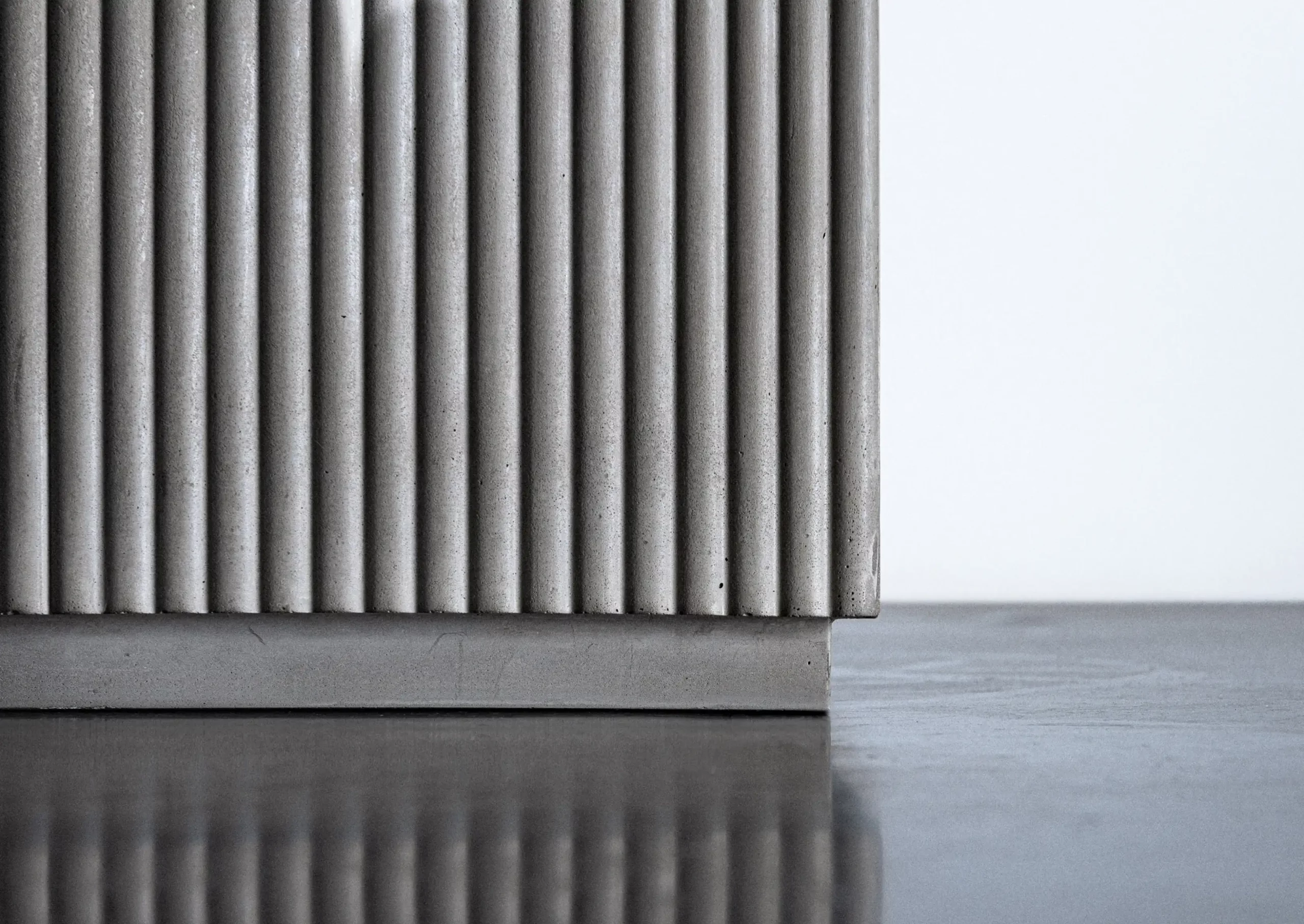 table basse en béton dans un salon minimaliste avec cheminée et décoration végétale