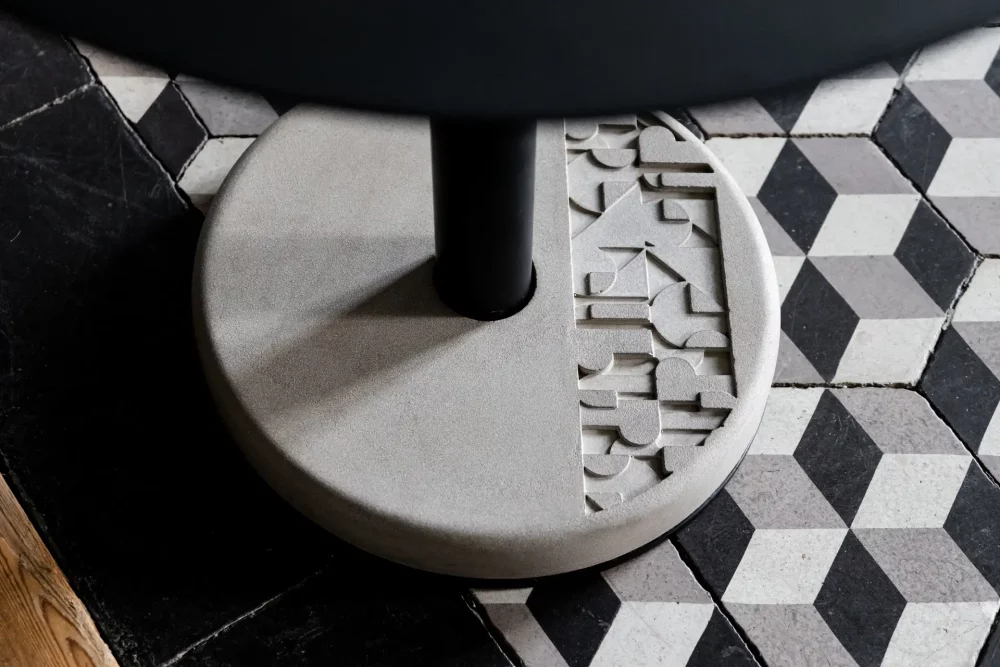 le lest rond en béton et orné de son motif inspiré du Bauhaus permet une parfaite stabilité de la table