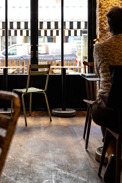 une personne accoudé à la table Donut devant la vitrine