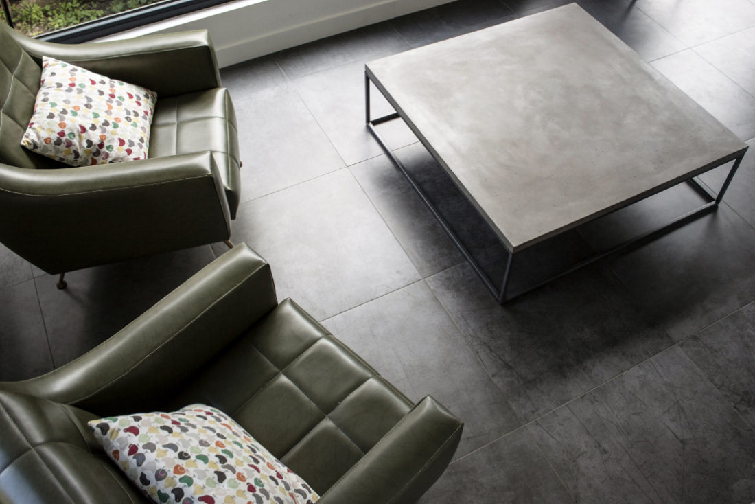 Two green skai armchairs from the 70s around a square concrete coffee table