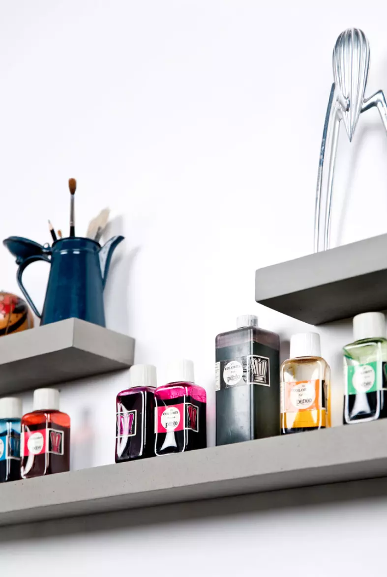 Starck citrus press and artist's tools placed on sliced shelves with invisible mounting system