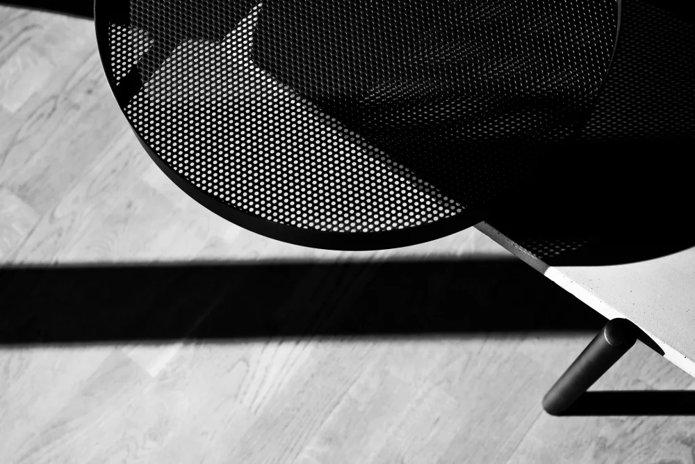 Le plateau perforé du plateau amovible de la table basse Twist est parfaitement mis en valeur dans cette photo en noir et blanc