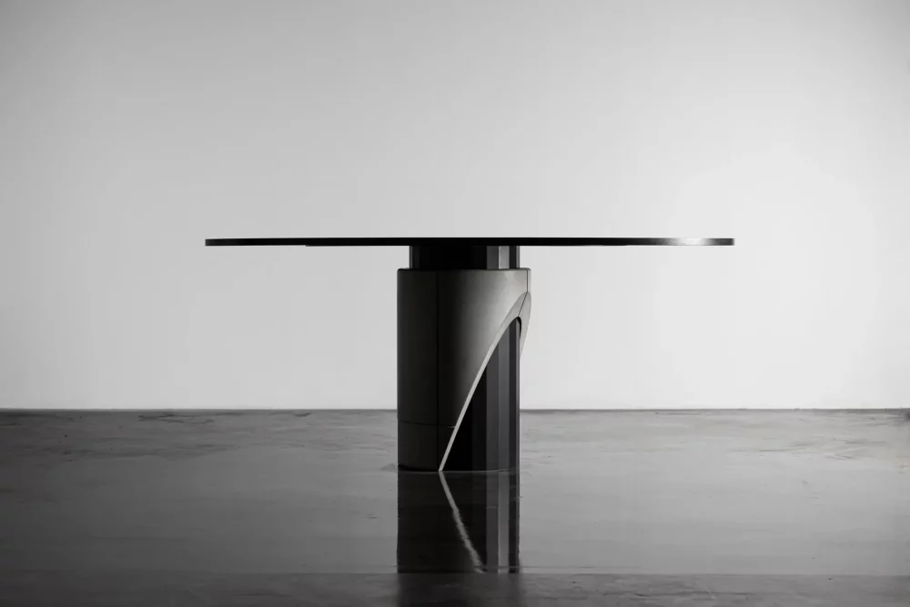 Table de repas pour 6 à 8 personnes plateau en bois teinté noir et pied en métal et béton pour un style moderne et brutaliste